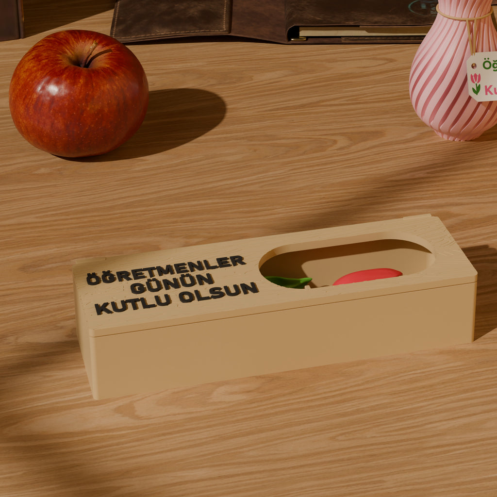 Öğretmen masasında kapağında Öğretmenler Günün Kutlu Olsun yazan çiçek kutusu